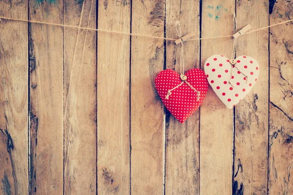 Two heart fabric hanging on clothesline and wood background with Stock Photo