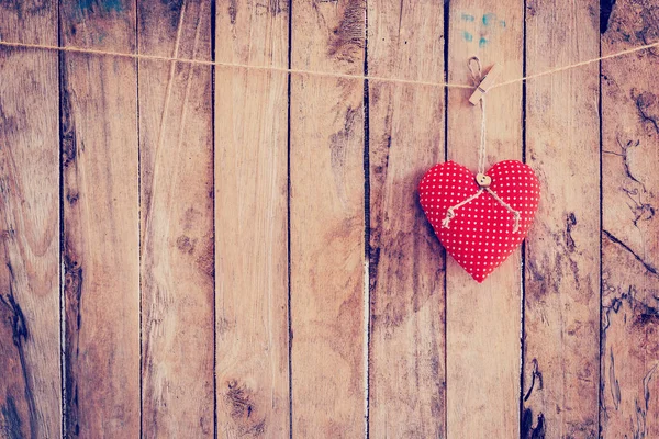 Tejido de corazón colgado en tendedero y fondo de madera con spa — Foto de Stock