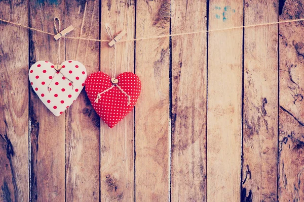Two heart fabric hanging on clothesline and wood background with — Stock Photo, Image