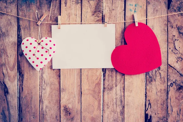 Dos corazones colgando y papel en tendedero y cuerda con madera — Foto de Stock