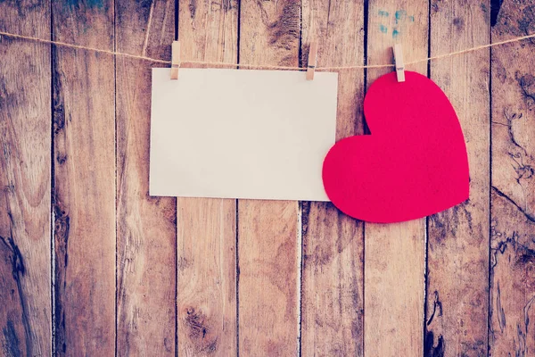 Corazón rojo colgando y papel en tendedero y cuerda con madera — Foto de Stock