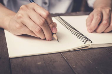 defter ahşap masa arka plan üzerinde yazma el kadın kapatmak.