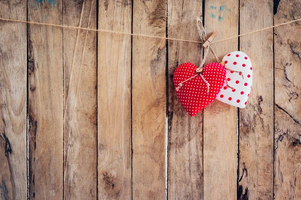 Tela de dos corazones colgando en tendedero y fondo de madera con — Foto de Stock