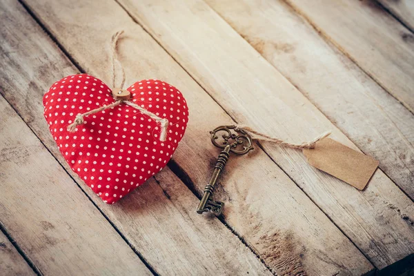 Heart fabric and vintage key with tag on wood table background. — Stock Photo, Image