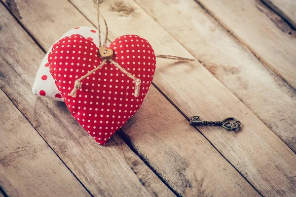 Corazón de tela y llave vintage sobre fondo de tabla de madera . — Foto de Stock