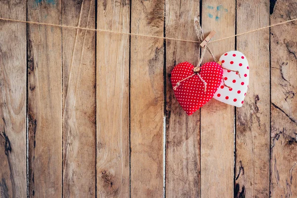 Two heart fabric hanging on clothesline and wood background with Stock Image