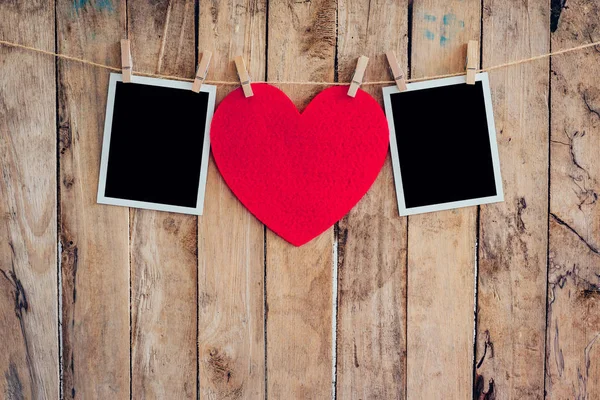 Red heart and two photo frame hanging on clothesline rope with w — Stock Photo, Image