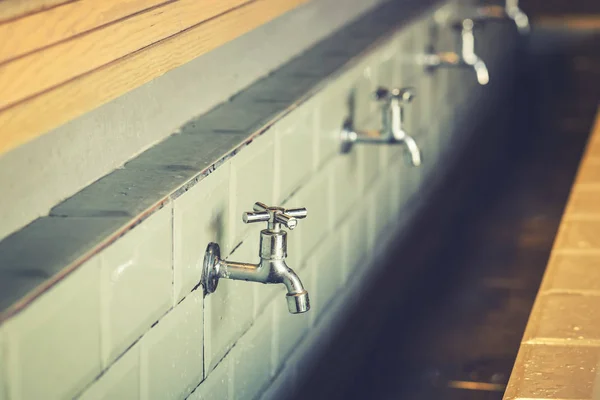 Reihe von Stahlhähnen in einem großen Badezimmer — Stockfoto