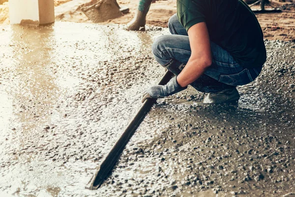 Estucador trabalhador concreto no chão da construção da casa — Fotografia de Stock