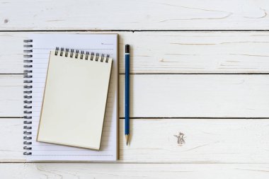 Açık defter ile boş sayfaları ve ahşap masa üzerinde kalem