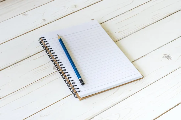 Open notebook with blank pages and pencil on wood table — Stock Photo, Image