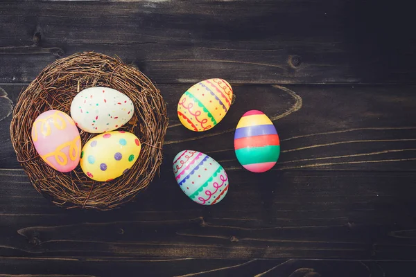 Яйца пасхальные в гнезде на деревянном фоне с копирайтом . — стоковое фото