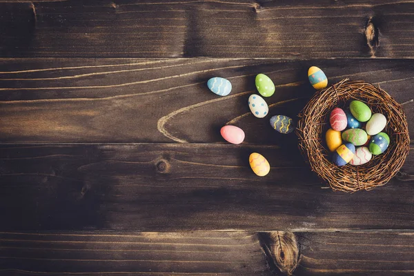 Färgglada ägg påsk i boet på trä bakgrund med copyspa — Stockfoto