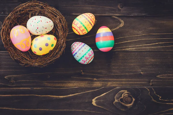 Uova colorate pasqua nel nido su fondo legno con copyspa — Foto Stock