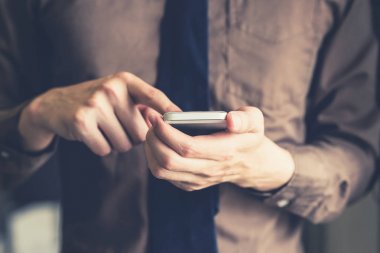 Holding ve ofiste smartphone kullanarak genç iş adamı wi