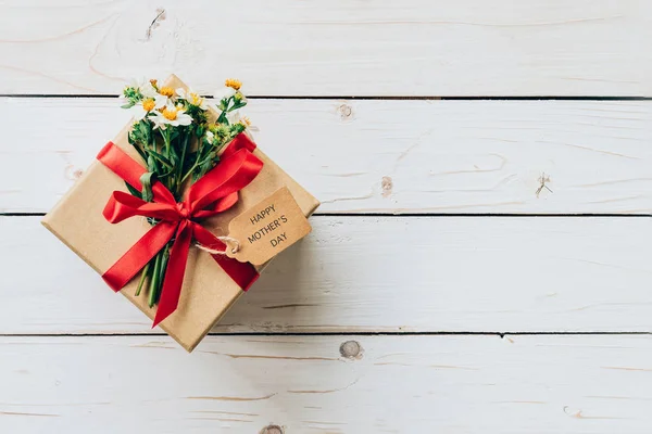 Scatola regalo marrone e fiore sul tavolo in legno presente, festa della mamma co — Foto Stock
