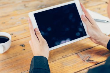 Vintage tonda filt ile kafede masada tablet kullanan adam