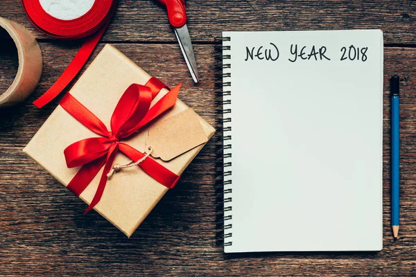 Año Nuevo 2018 en papel en blanco libro de notas sobre fondo de tabla de madera . — Foto de Stock
