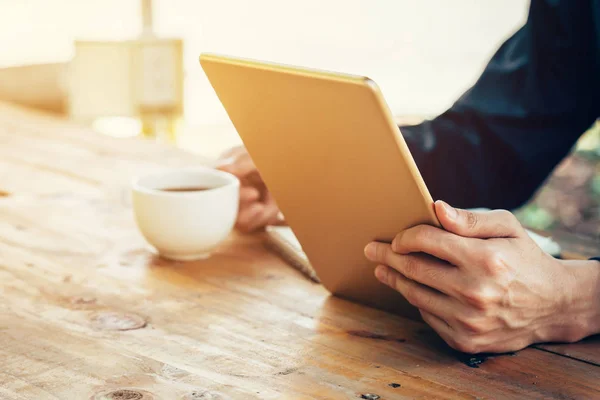 Homem de negócios usando tablet na mesa de madeira no café . — Fotografia de Stock