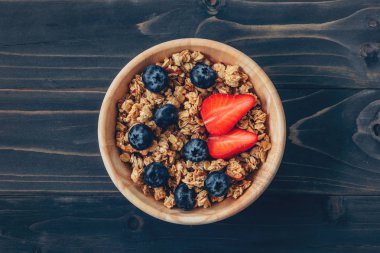 Ev yapımı granola ve uzay ile ahşap masa üzerinde taze çilek.