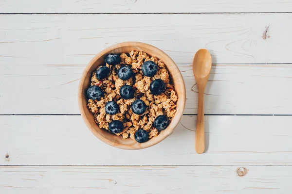 Hausgemachtes Müsli und frische Beeren auf Holztisch mit Platz. — Stockfoto