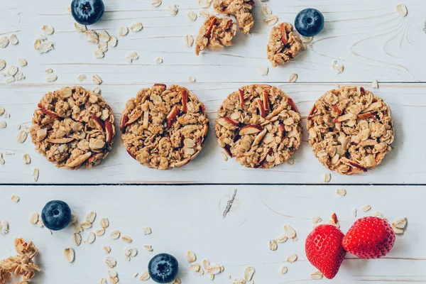 Homemade granola bar and fresh berries on wood table with space. — Stock Photo, Image