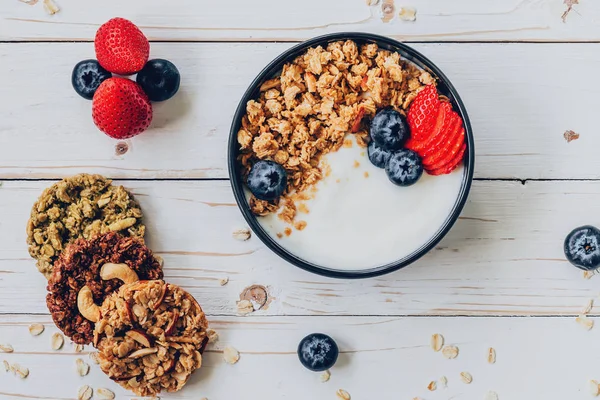 Bowl of granola with yogurt, fresh berries, strawberry on wood t — Stock Photo, Image