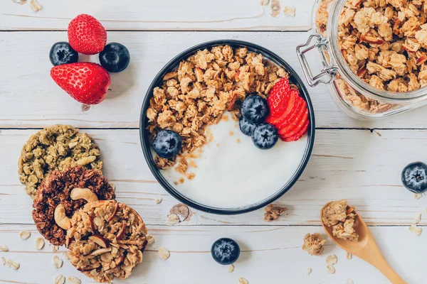 Bowl of granola with yogurt, fresh berries, strawberry on wood t — Stock Photo, Image