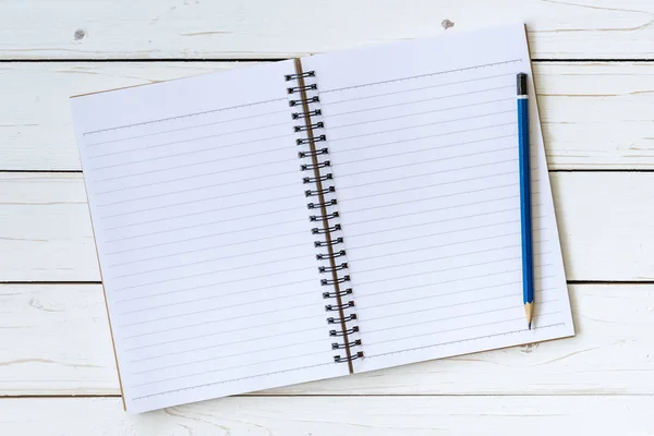 Bovenaanzicht open boek op houten tafel met potlood. — Stockfoto