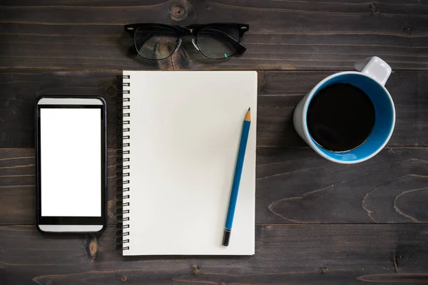 Büroholztisch mit Notizblock, Bleistift, Brille, Telefon und — Stockfoto