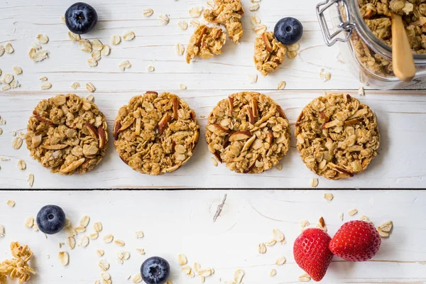 Hausgemachte Müsliriegel und frische Beeren auf Holztisch mit Platz. — Stockfoto