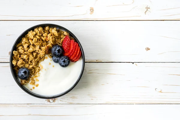Tazón de granola con yogur, bayas frescas, fresa en madera t — Foto de Stock