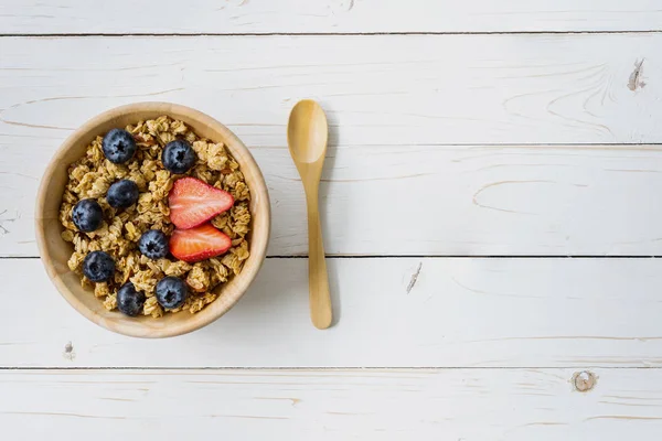 Hausgemachtes Müsli und frische Beeren auf Holztisch mit Platz. — Stockfoto