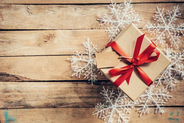 Cajas de regalo de Navidad colocadas y copos de nieve blancos en tablón de madera — Foto de Stock