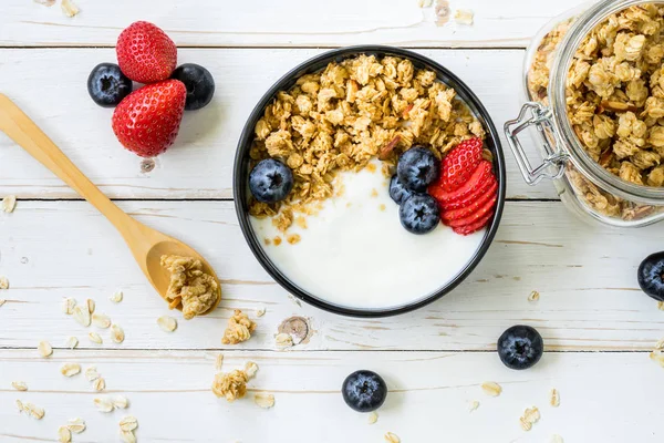 Bowl of granola with yogurt, fresh berries, strawberry on wood t — Stock Photo, Image