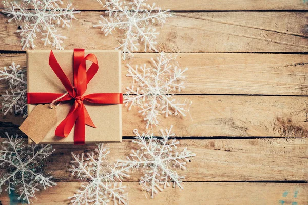 Cajas de regalo de Navidad colocadas y copos de nieve blancos en tablón de madera — Foto de Stock