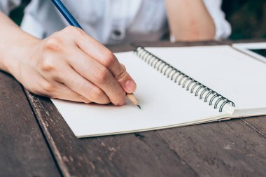 Hipster kadın el kahve dükkanında defter kağıt yazma.