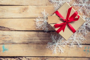 Ahşap tahta üzerine yerleştirilmiş ve beyaz kar tanesi Noel hediye kutuları