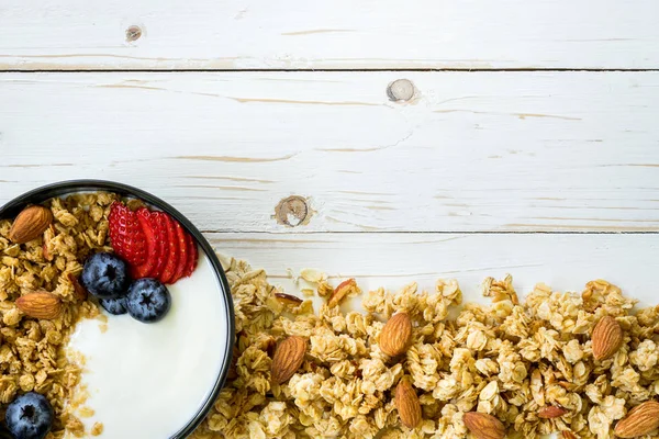 Schüssel Müsli mit Joghurt, frischen Beeren, Erdbeere auf Holz — Stockfoto