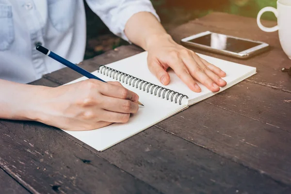 Hipster kadın el kahve dükkanında defter kağıt yazma.