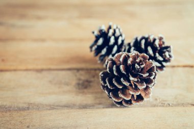 Çam kozalağı alan ahşap masa zemin üzerine.