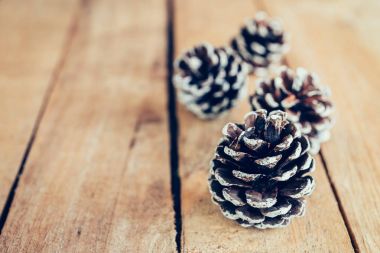 Çam kozalağı alan ahşap masa zemin üzerine.