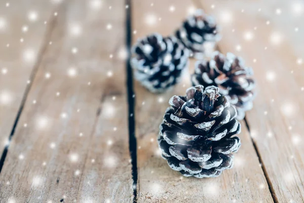 Ahşap masa arka plan boşluk ile çam koni ve beyaz kar.