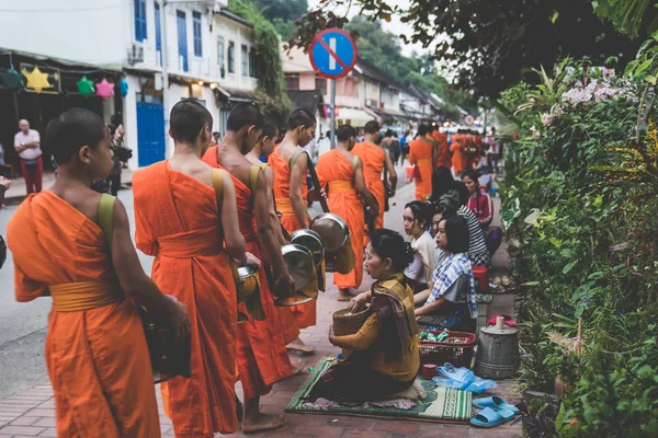 L'elemosina buddista che fa la cerimonia di mattina. La tradizione di dare l'elemosina ai monaci a Luang Prabang è stata estesa ai turisti. . — Foto Stock