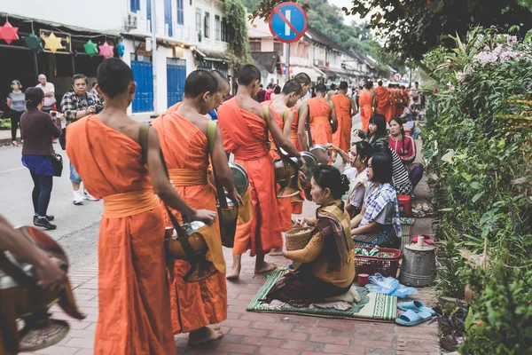 L'elemosina buddista che fa la cerimonia di mattina. La tradizione di dare l'elemosina ai monaci a Luang Prabang è stata estesa ai turisti. . — Foto Stock