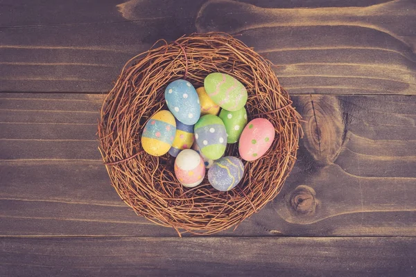 Цветные пасхальные яйца аккуратно на деревянном фоне с спа — стоковое фото