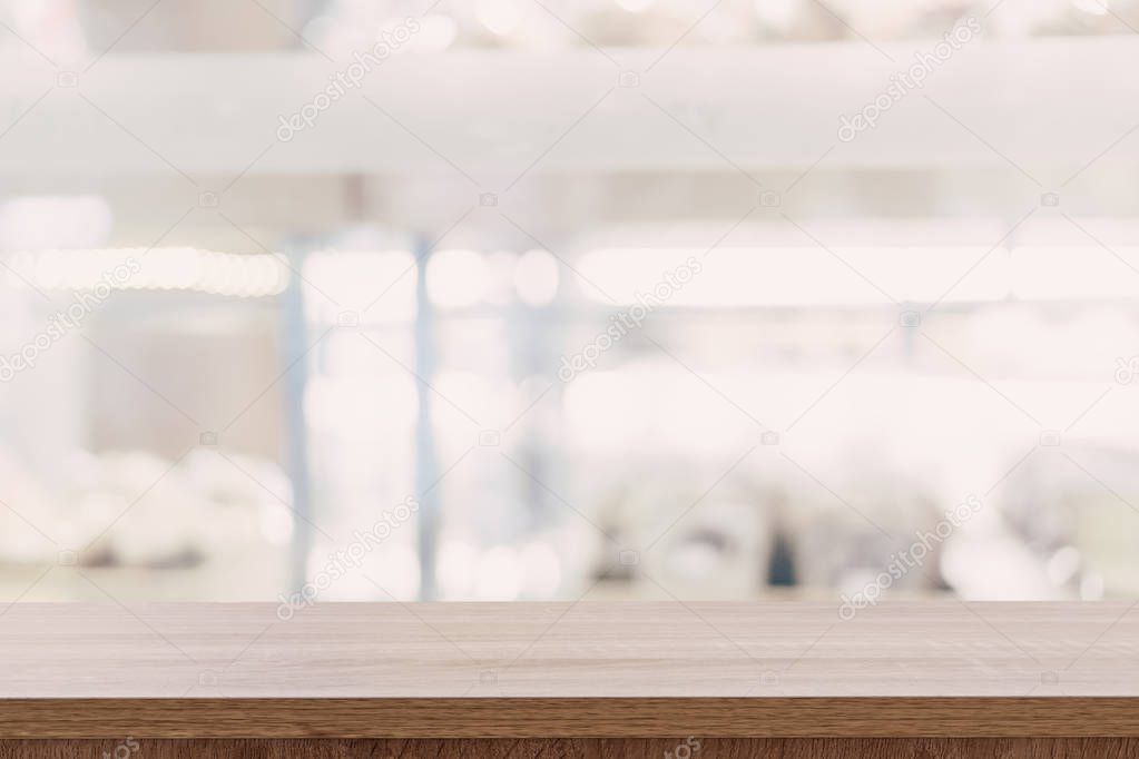 Empty wooden table top with blurred modern shopping mall backgro