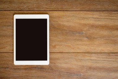 Te yeri olan ahşap masa arka plan boş Tablet bilgisayarda