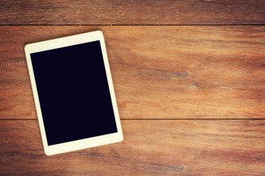Te yeri olan ahşap masa arka plan boş Tablet bilgisayarda