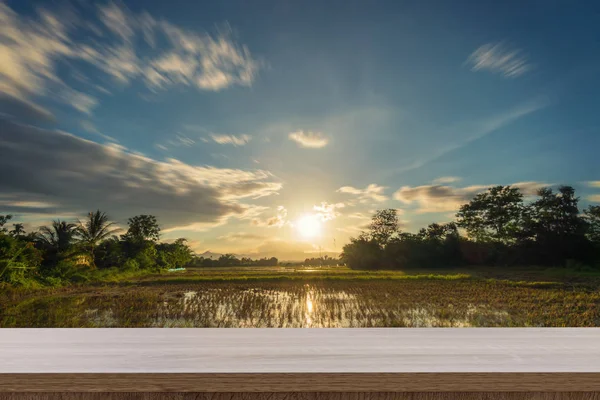 Campo di riso tramonto e tavolo in legno vuoto per l'esposizione del prodotto e m — Foto Stock
